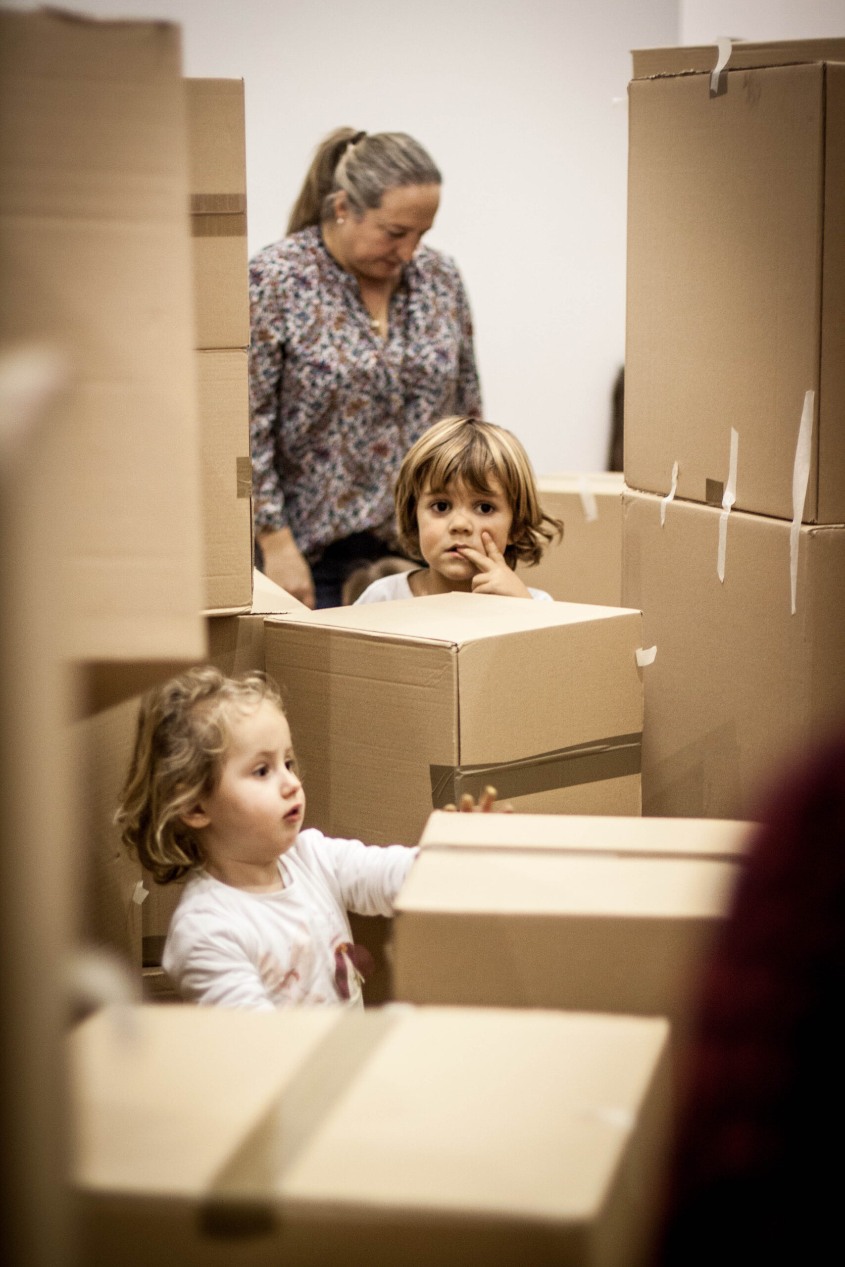 Niñas jugando entre estructuras de cartón.