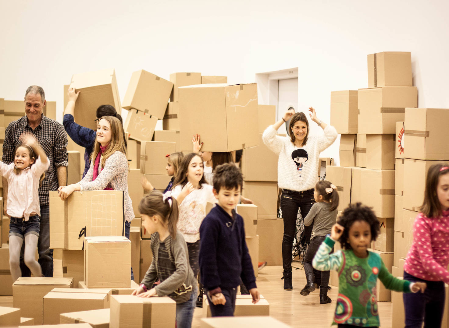 Grupo corriendo entre grandes construcciones de cajas.