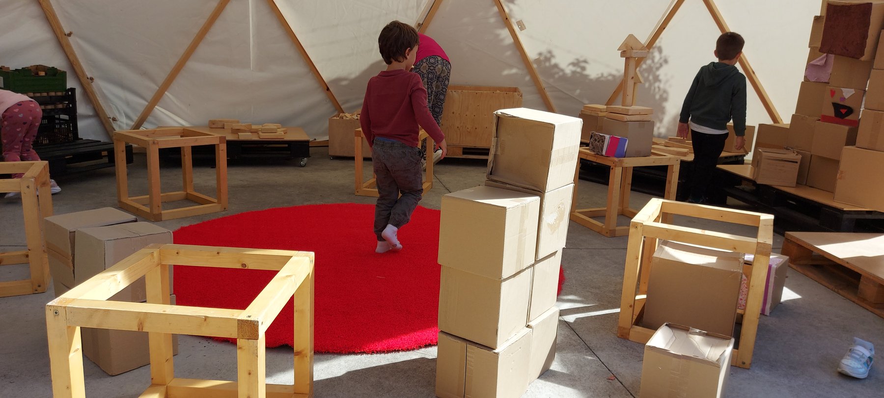 Niños exploran construcciones y materiales dentro de un domo.