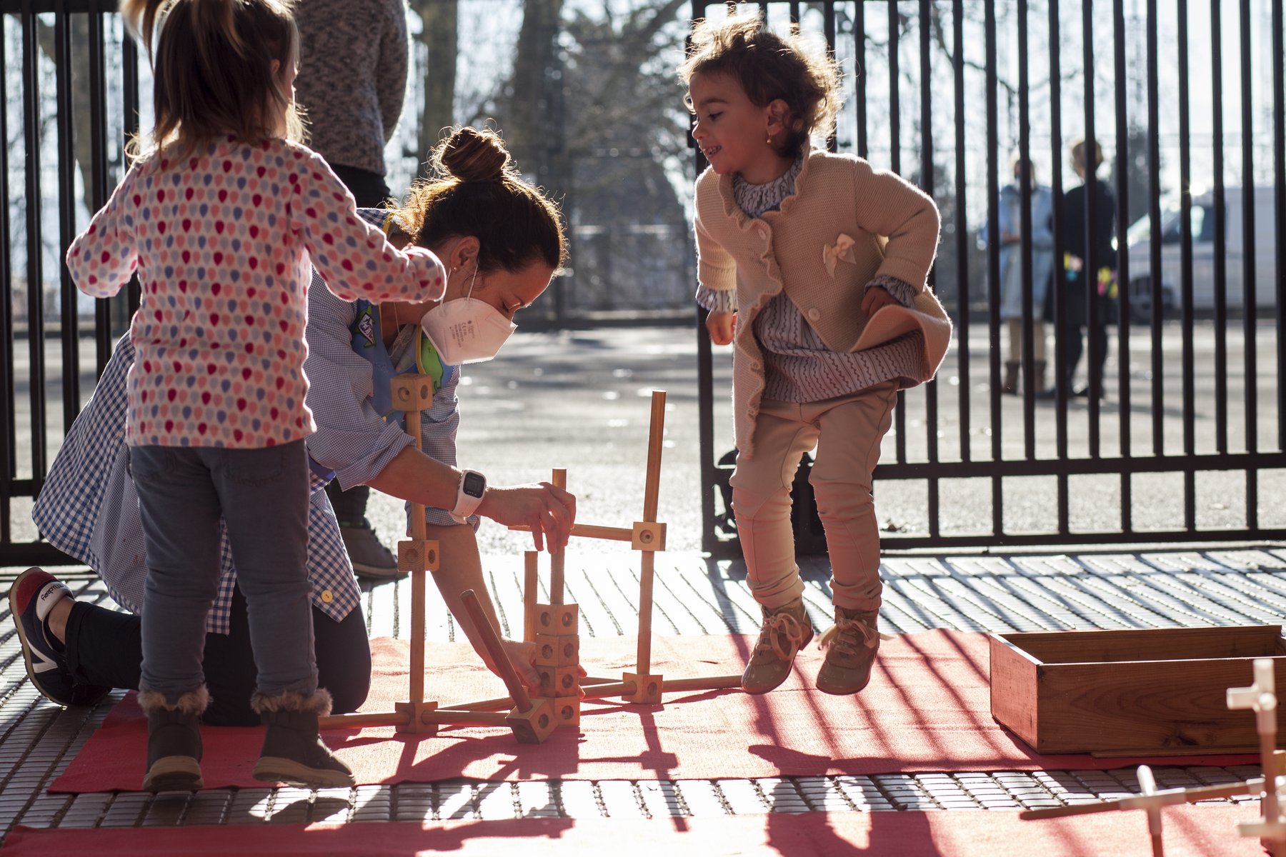 Niñas construyen con madera a contraluz.