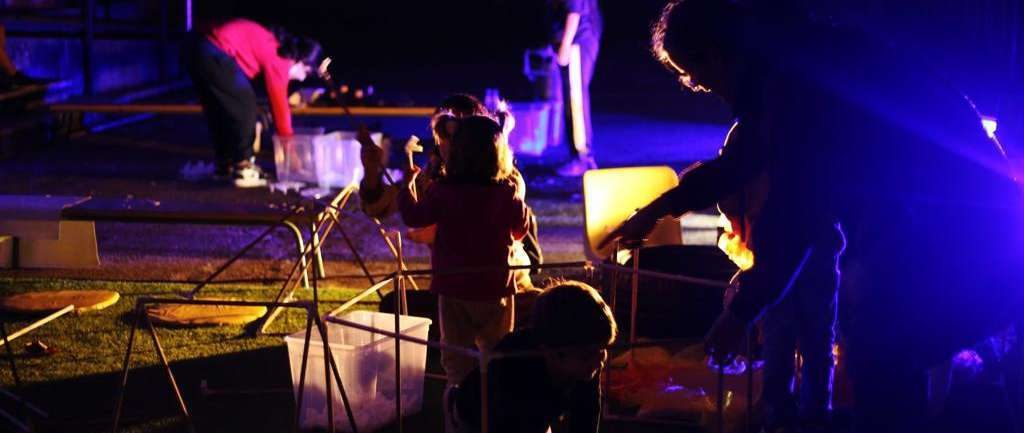Familias activando de noche las estructuras luminosas de Irisada.