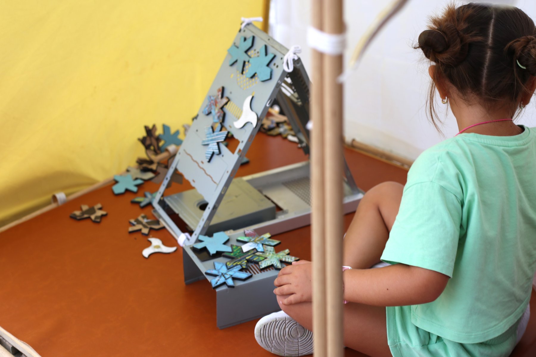 Niña componiendo piezas durante un taller familiar.