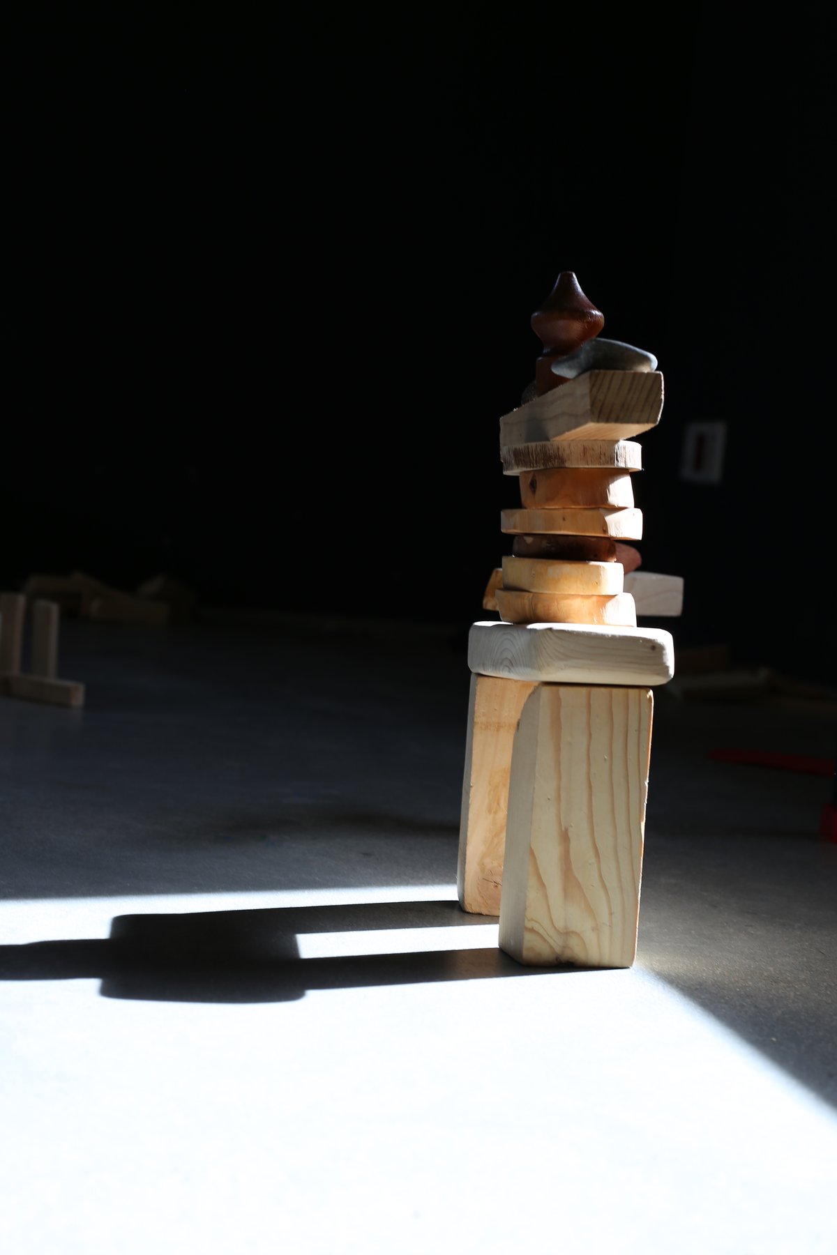 Figuras construidas con piezas sueltas proyectan sombras junto a una ventana.