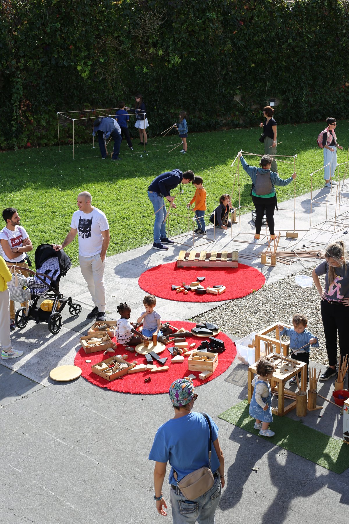 Participantes construyen estructuras con varillas en los jardines.