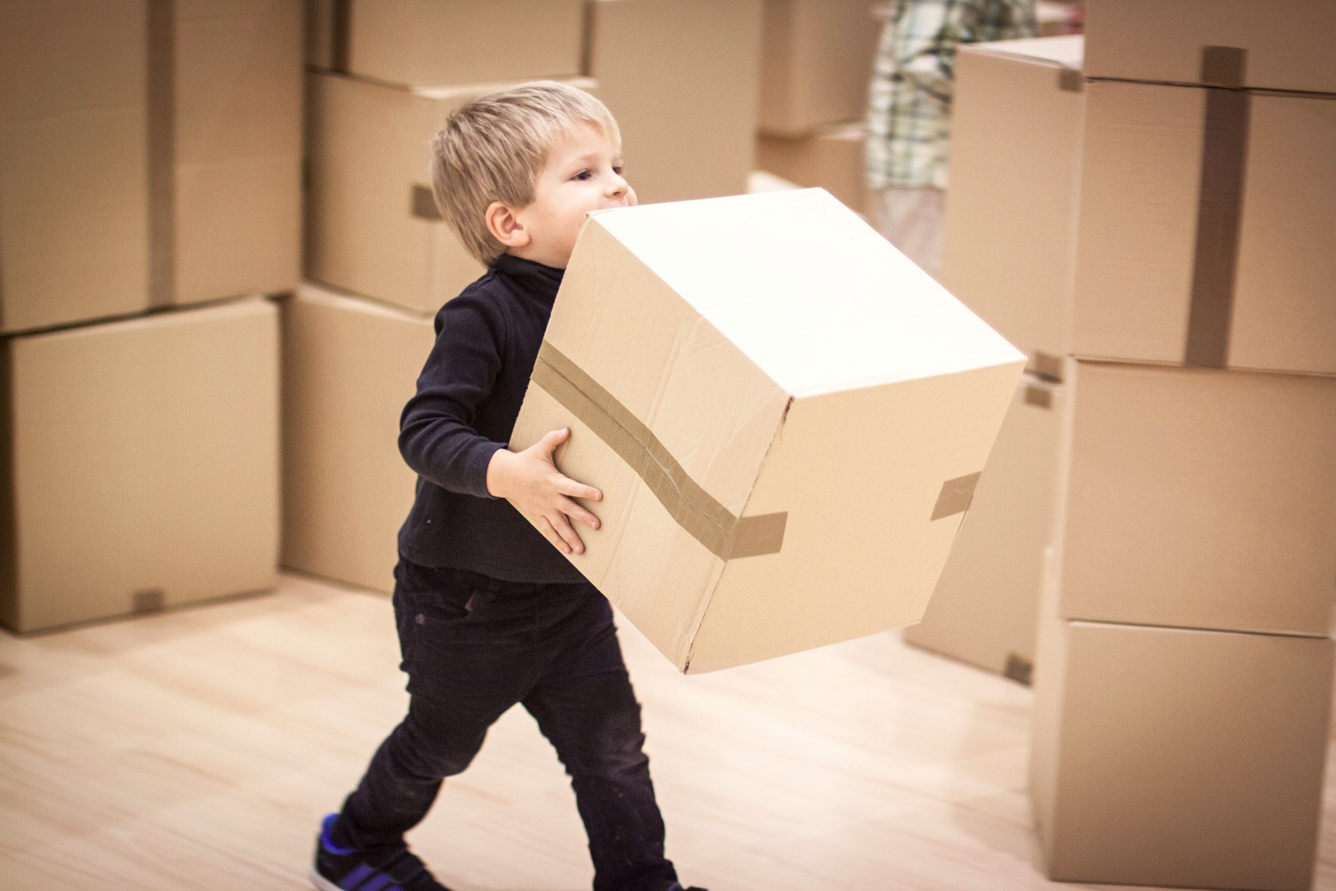 Niño transportando cajas para iniciar la construcción.