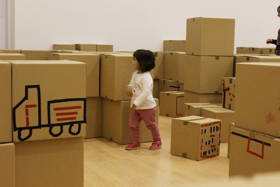 Niña habitando una ciudad de cartón terminada.