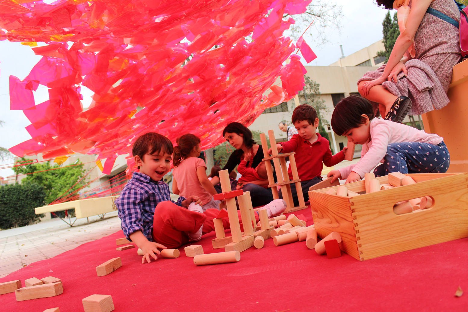 Niñas y niños construyen con piezas de madera dentro del espacio de taller.