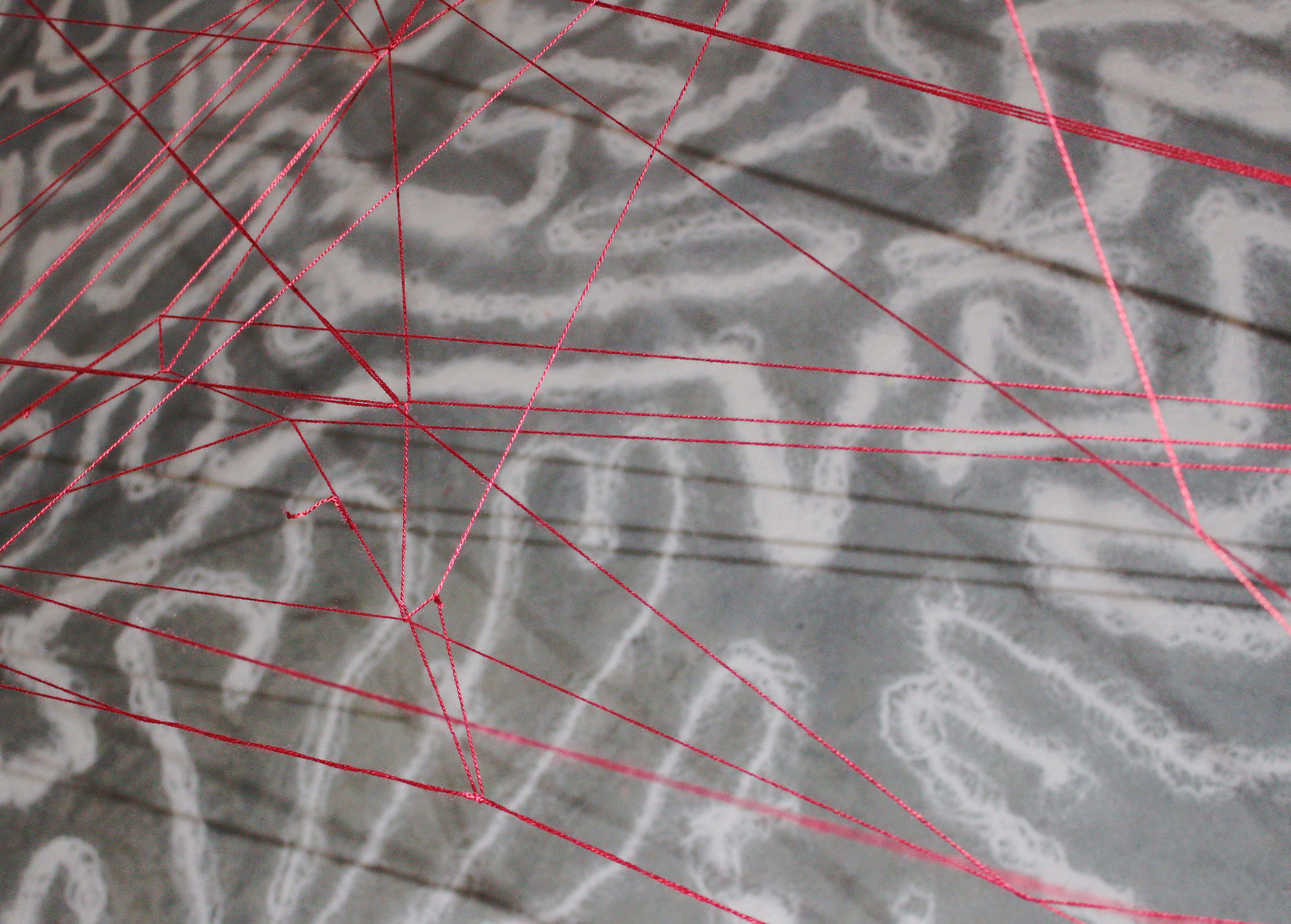 Detalle de líneas rojas sobre una superficie textil.