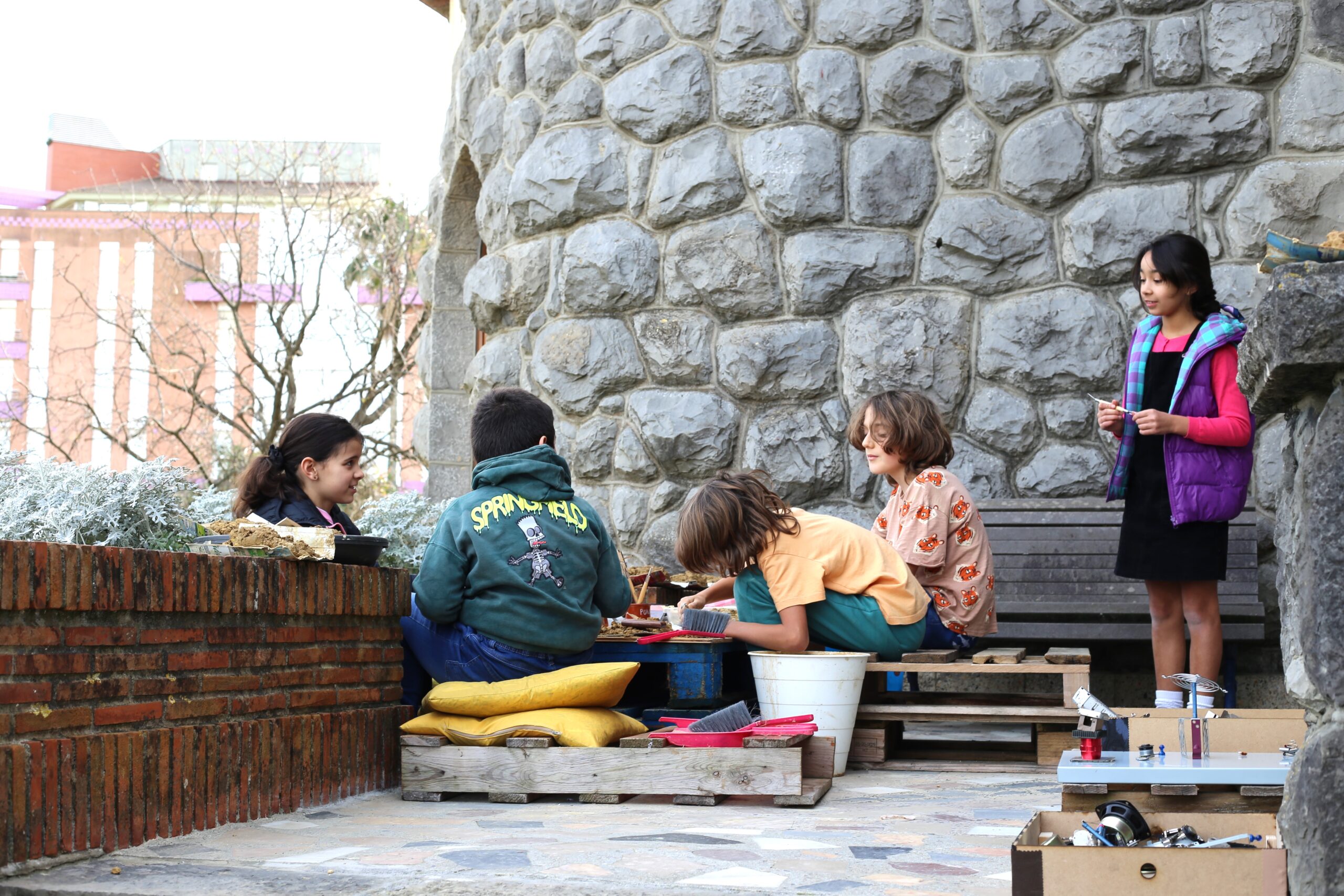Grupo de participantes reunido alrededor de una mesa de exploración en el exterior.