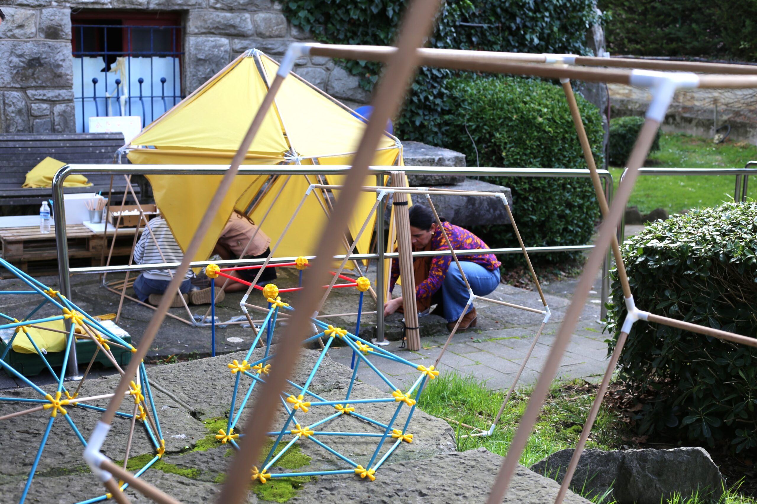 Participantes entre estructuras de barras y superficies triangulares amarillas en el exterior.