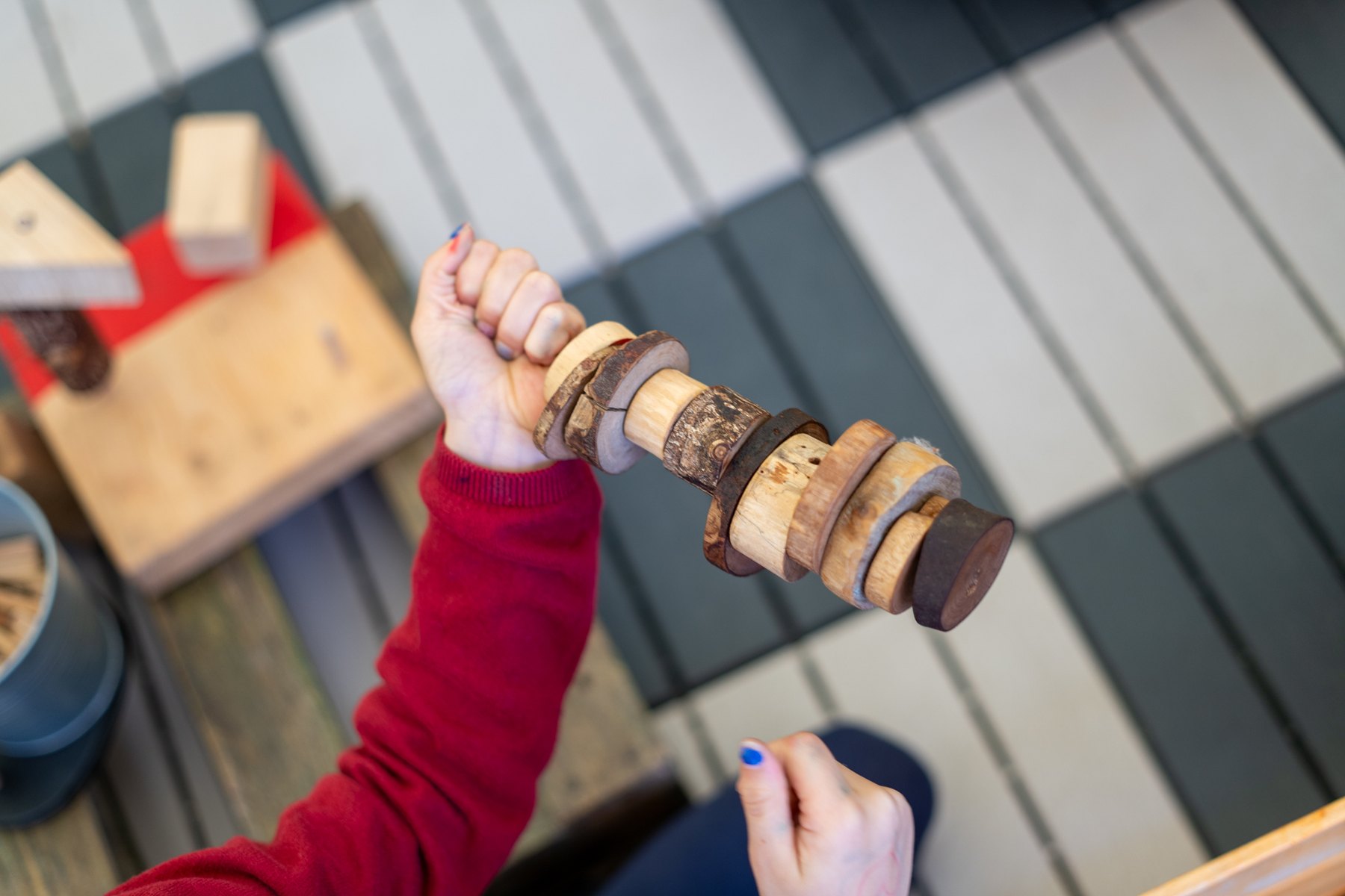 Detalle de una construcción de discos de madera sostenida en la mano.