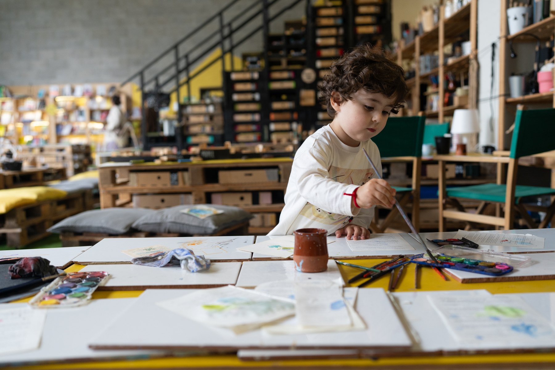 Un niño experimenta con sellos y tinta sobre papel.