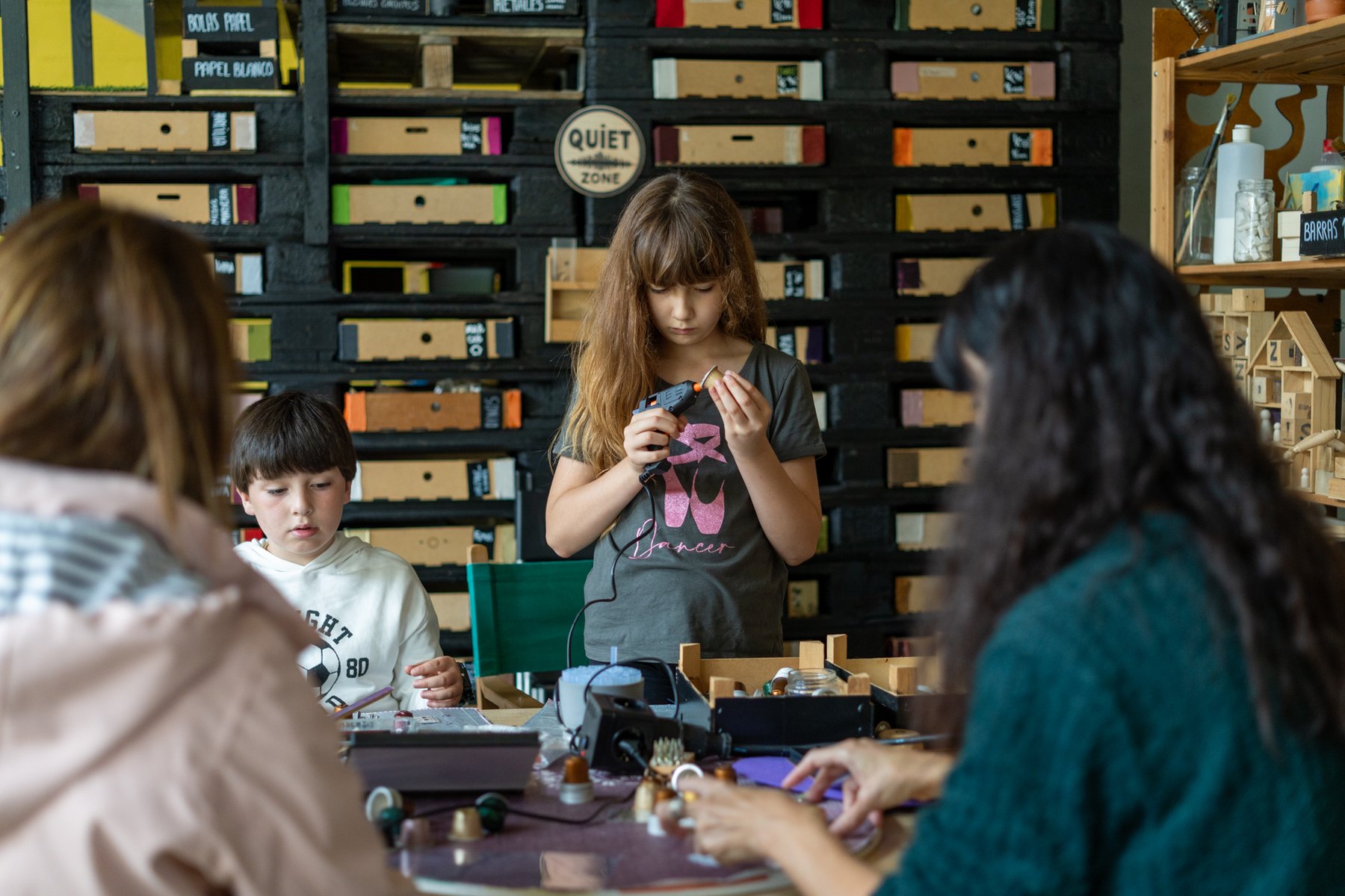 Familias explorando piezas de madera en una mesa.