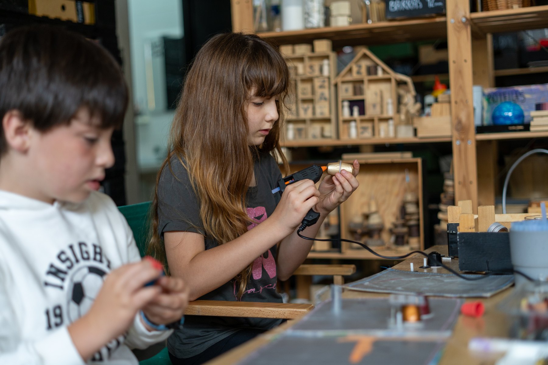 Dos niños manipulan piezas y pequeños objetos en la Sala Amarilla.